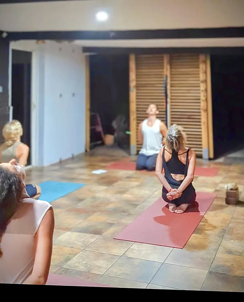 Élèves assis sur les talons, le dos droit, pendant un cours de yoga