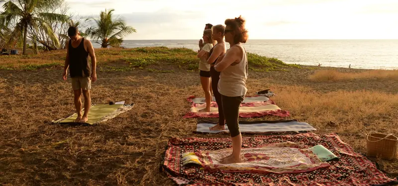 Cours collectif de yoga en plein air, au bord de l'océan