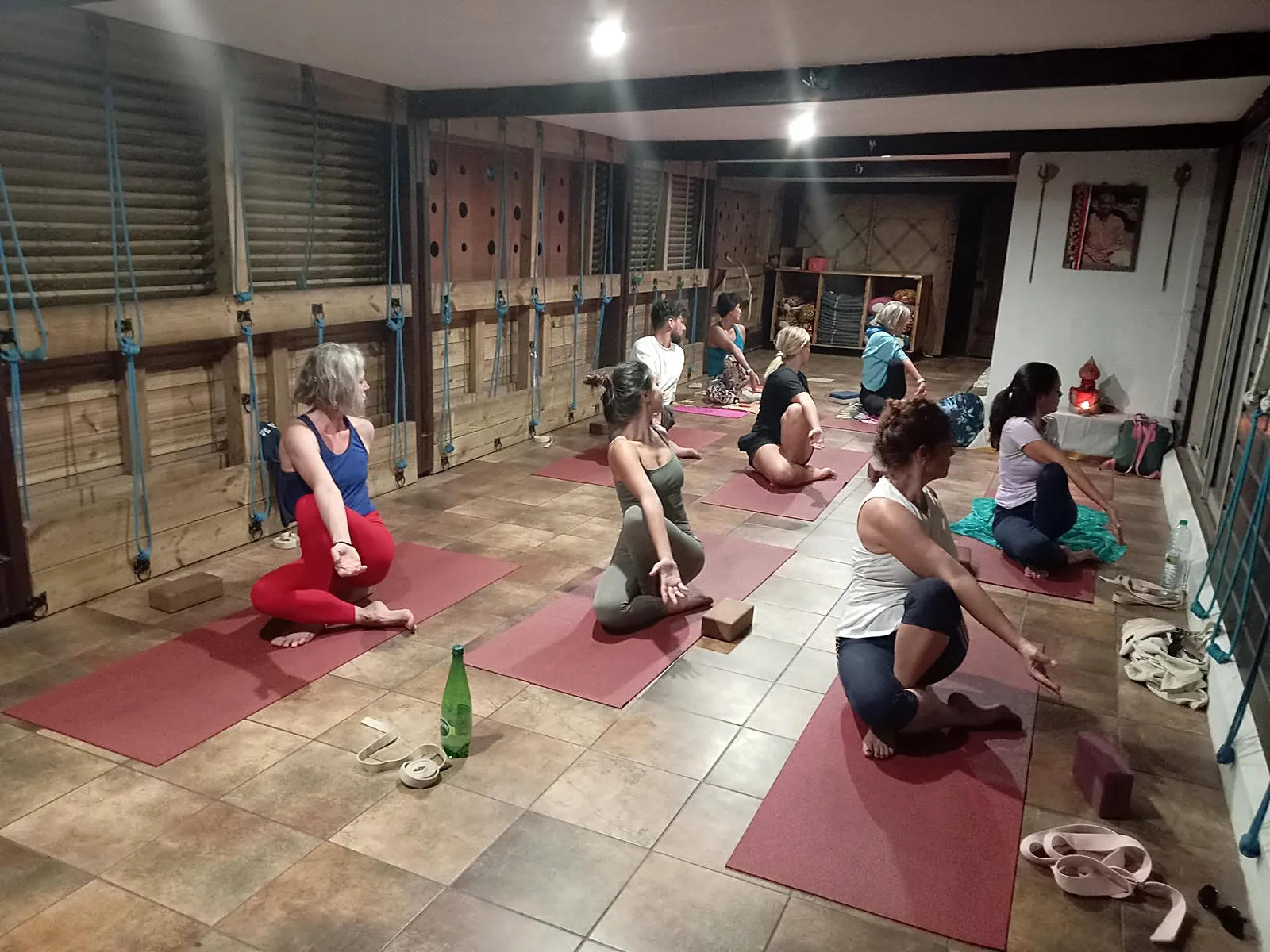 Cours collectif de yoga en salle, élèves en torsion assise