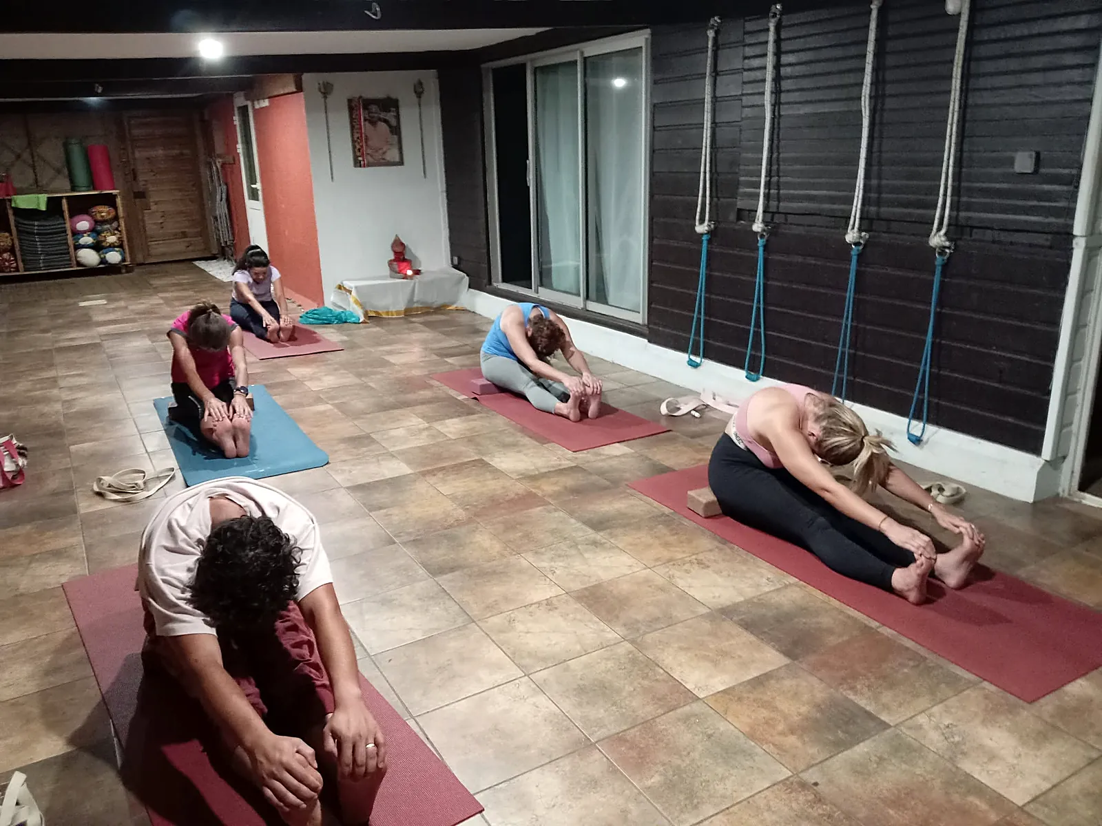 Élèves en flexion avant assise pendant un cours de yoga en salle